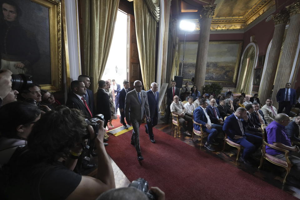 National Assembly President Jorge Rodriguez, center, arrives for a signing ceremony that agrees on various presidential election dates to propose to the National Elections Council (CNE) at the National Assembly in Caracas, Venezuela, Wednesday, Feb. 28, 2024. Next to him is lawmaker Diosdado Cabello. (AP Photo/Matias Delacroix)