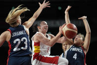 Spain's Silvia Dominguez, center, drives to the basket between France's Marine Johannes (23) and Marine Fauthoux (4) during a women's basketball quarterfinal round game at the 2020 Summer Olympics, Wednesday, Aug. 4, 2021, in Saitama, Japan. (AP Photo/Eric Gay)