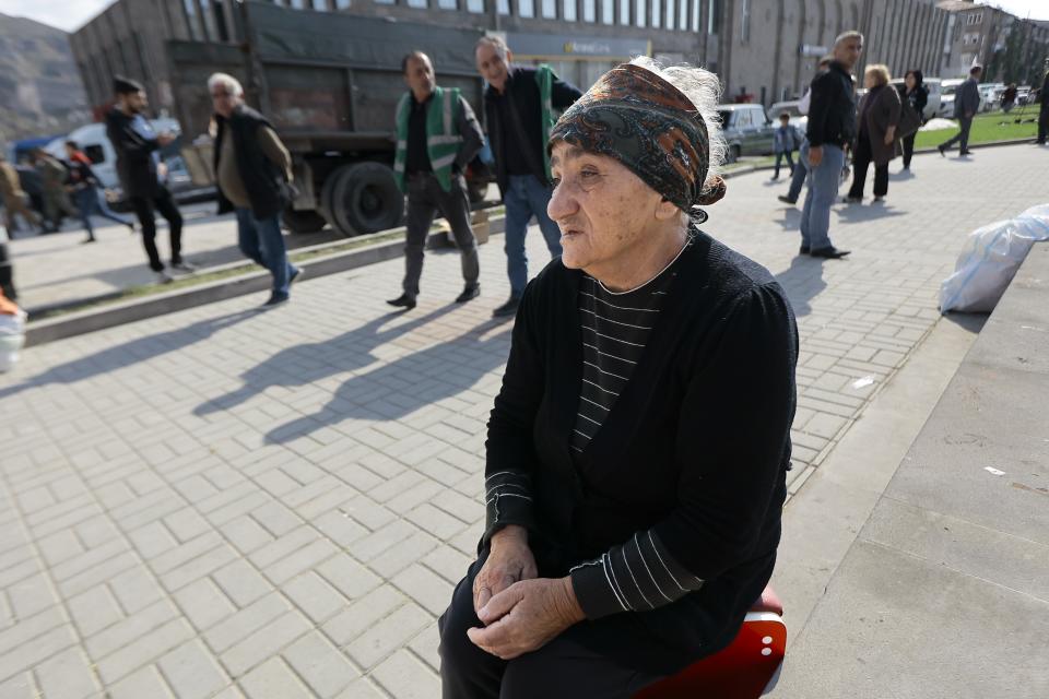 An ethnic Armenian woman from Nagorno-Karabakh sits on her suitcase after arriving to Armenia's Goris in Syunik region, Armenia, Friday, Sept. 29, 2023. Armenian officials say more than 70% of Nagorno-Karabakh's original population have fled the region for Armenia. (AP Photo/Vasily Krestyaninov)