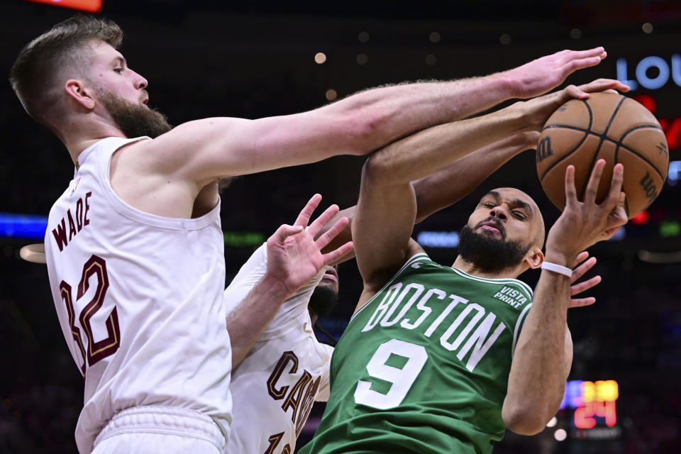 Boston Celtics guard Derrick White (9) is defended by Cleveland Cavaliers forward Dean Wade and guard Darius Garland during the second half of Game 4 of an NBA basketball second-round playoff series, Monday, May 13, 2024, in Cleveland. (AP Photo/David Dermer)