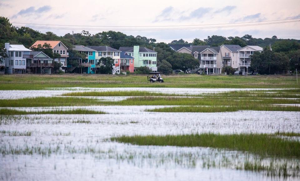 A golf cart navigates a low-lying causeway between Murrells Inlet and Garden City Beach, South Carolina in August 2021. The causeway floods often during storm events and National Ocean Service officials say the flooding is only expected to get worse with sea level rise.