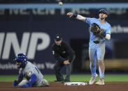 Toronto Blue Jays second baseman Cavan Biggio, right, forces out Kansas City Royals' Maikel Garcia, left, at second but cannot turn a double play during ninth-inning baseball game action in Toronto, Monday, April 29, 2024. (Nathan Denette/The Canadian Press via AP)