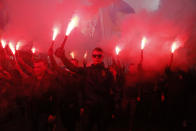 Members of the nationalist movements light flares during a rally marking Defense of the Homeland Day in center Kyiv, Ukraine, Monday, Oct. 14, 2019. Some 15,000 far-right and nationalist activists protested in the Ukrainian capital, chanting "Glory to Ukraine" and waving yellow and blue flags. President Volodymyr Zelenskiy urged participants to avoid violence and warned of potential “provocations” from those who want to stoke chaos. (AP Photo/Efrem Lukatsky)