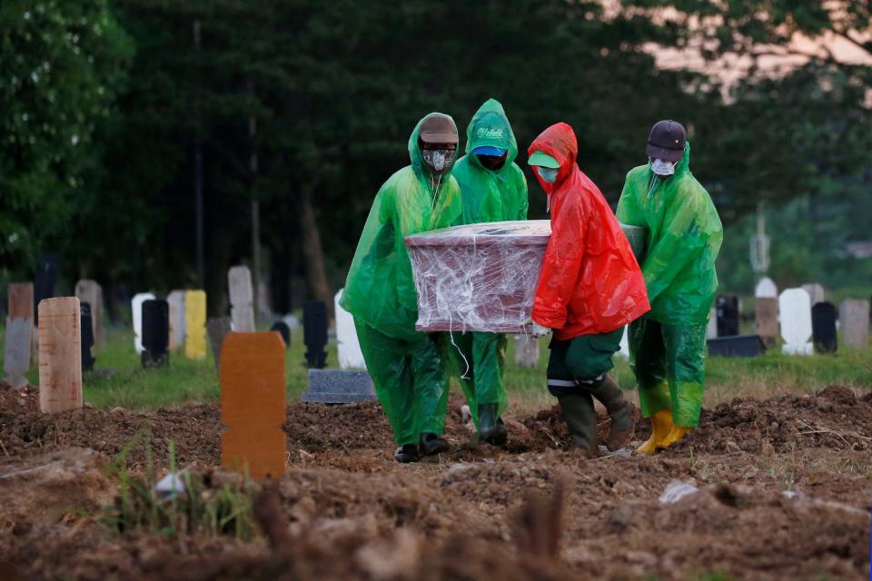 Municipality workers carry a coffin of a doctor who passed away due to the coronavirus disease during a funeral in Jakarta, Indonesia on March 31.