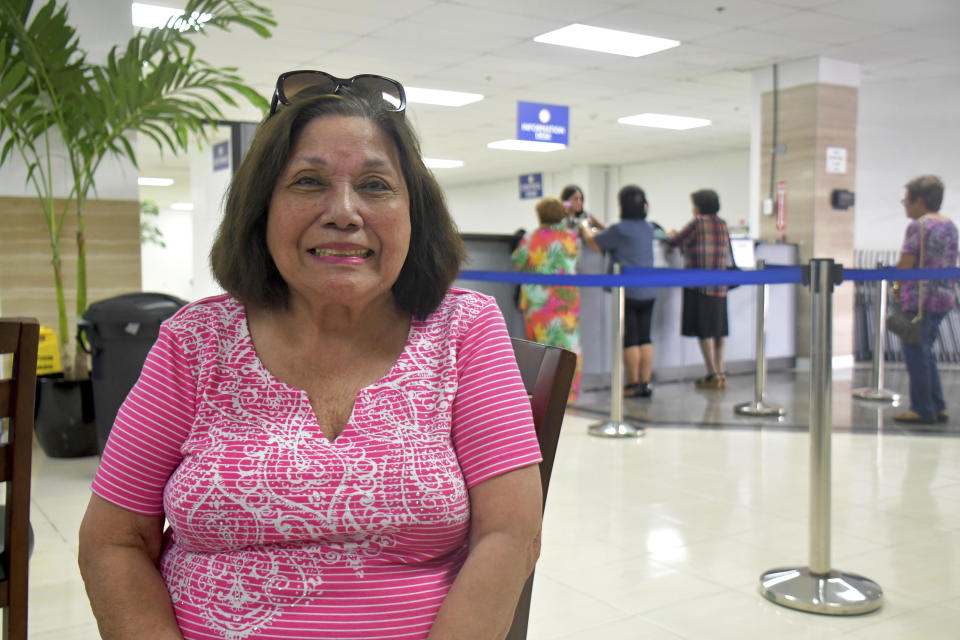 In this Friday, Feb. 7, 2020 photo, Antonina Palomo Cross, 85, sits at the Guam war claims office in Tamuning, Guam after getting confirmation that she will receive a payment for her experience living through the Japanese occupation of the U.S. Pacific island territory in 1941. The 1941 Japanese invasion of Guam, which happened on the same December day as the attack on Hawaii's Pearl Harbor, set off years of forced labor, internment, torture, rape and beheadings. Now, more than 75 years later, thousands of people on Guam, a U.S. territory, are expecting to get long-awaited compensation for their suffering at the hands of imperial Japan during World War II. (AP Photo/Anita Hofschneider)