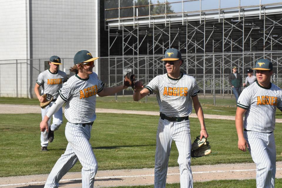 Sand Creek's Carson Preston, left, greets Jordan Illenden after finishing an inning during a game against Athens.