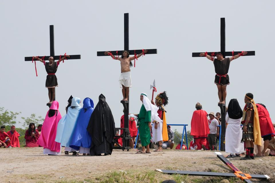 Ruben Enaje, centre, stays on the cross beside two other devotees during a reenactment of Jesus Christ’s sufferings as part of Good Friday rituals (AP)