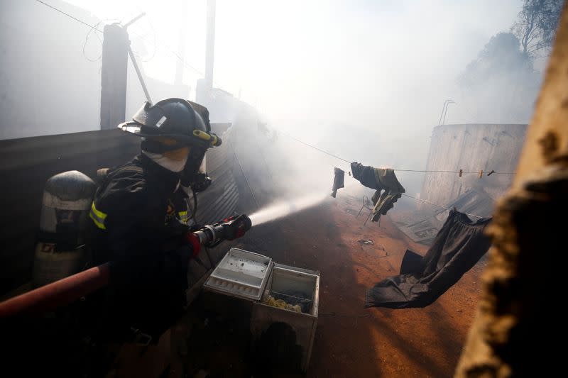 A firefighter works to extinguish a fire in Valparaiso