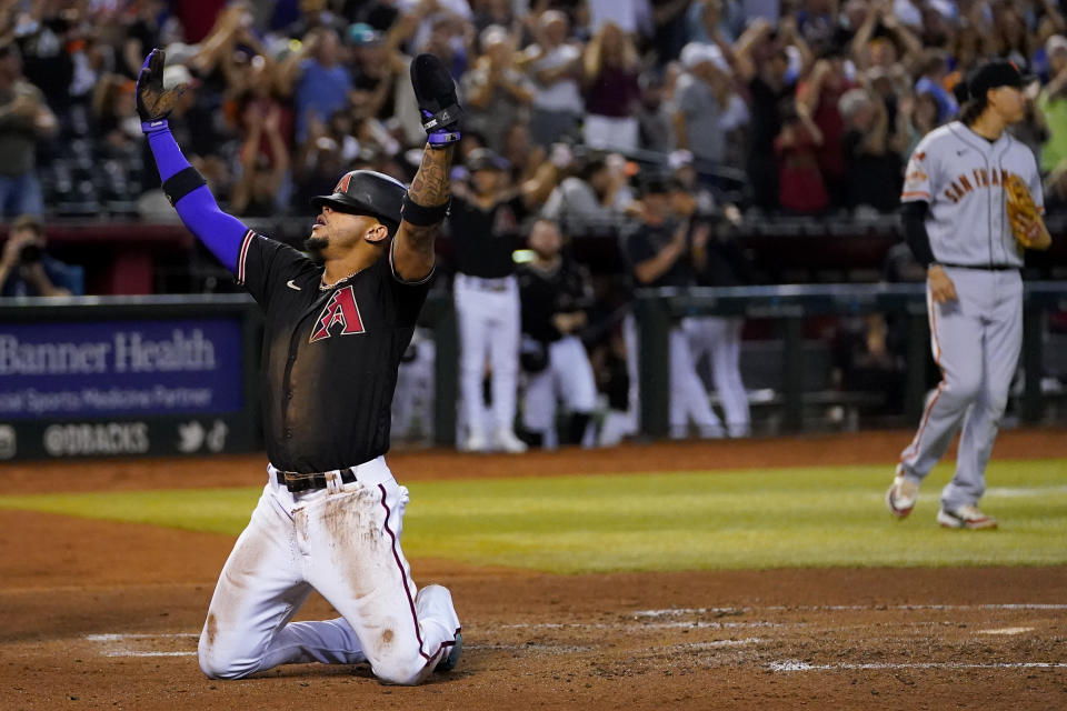 Arizona Diamondbacks' Ketel Marte celebrates scoring on a throwing error after stealing second during the second inning of a baseball game against the San Francisco Giants, Tuesday, Sept. 19, 2023, in Phoenix. (AP Photo/Matt York)