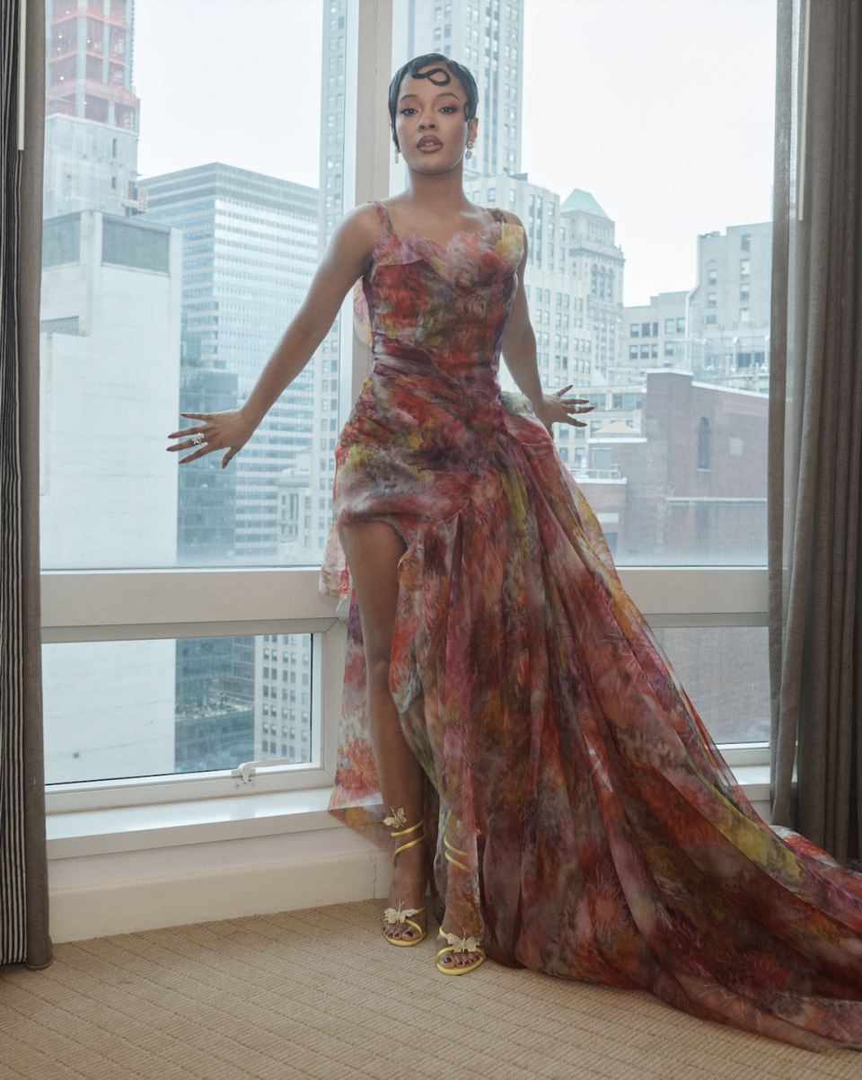 a woman wearing a floral dress in a hotel suite