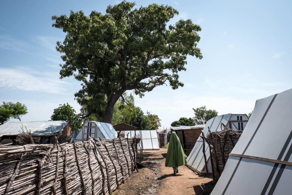 Women displaced by Boko Haram walk in front of their tents in Sabon Gari, Nigeria.