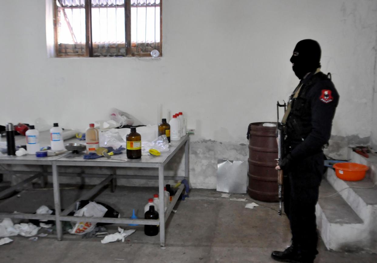 An Albanian police officer searches a clandestine cocaine refining laboratory in the village of Xibrake, near Elbasan, on January 15, 2015. Around 100 kilograms of elaborated cocaine and 18.8 kilograms of pure cocaine were found in the laborator: AFP via Getty Images