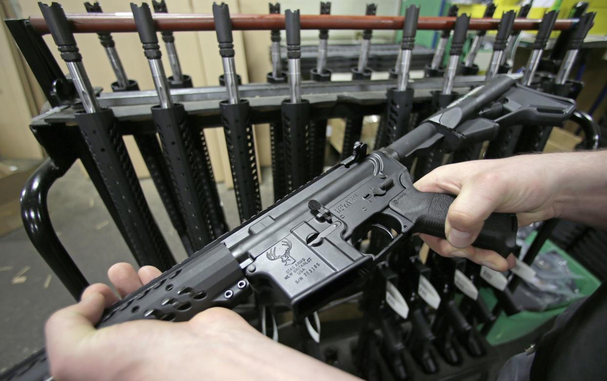 A man holds a newly-assembled AR-15 rifle in New Britain, Conn. in this 2013 file photo. Federal prosecutors have argued that devices sold by a Clay County business owner, Kristopher "Justin" Ervin, were designed to be cut apart and used to illegally convert semiuautomatic AR-15s into fully automatic machine guns.
(Photo: Charles Krupa/AP)