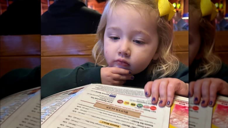 Girl reading Texas Roadhouse menu