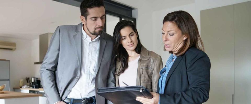 Couple with real-estate agent visiting modern house