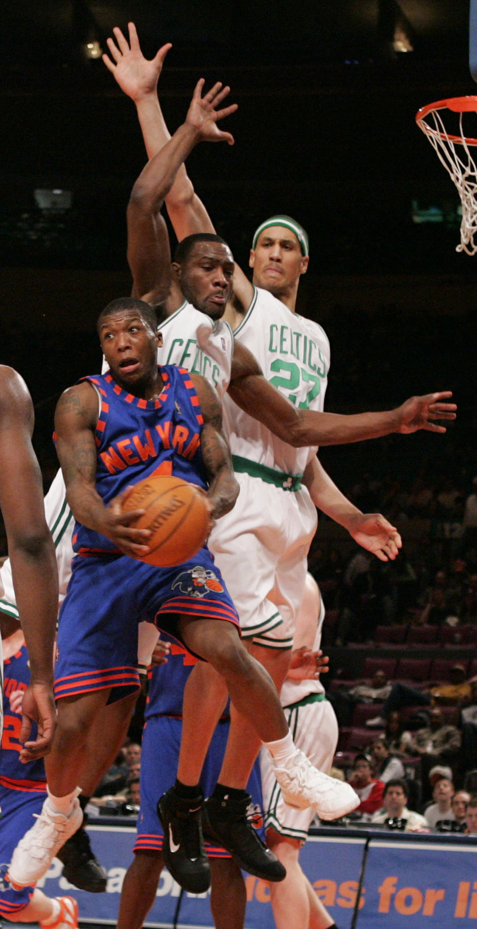 New York Knicks’ Nate Robinson, left, looks to pass the ball off in mid-air against Boston Celtics’ Tony Allen, center, and Dwayne Jones during the fourth quarter in NBA basketball action Wednesday, March, 29, 2006 at Madison Square Garden in New York. The Celtics won 123-98. (AP Photo/Julie Jacobson)