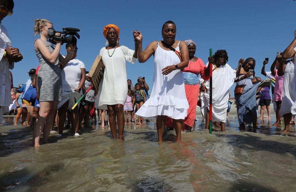 Lila Womack of Atlanta, center,dances as she wades into the water Sunday during the 8th Annual Tybee Juneteenth Wade In.