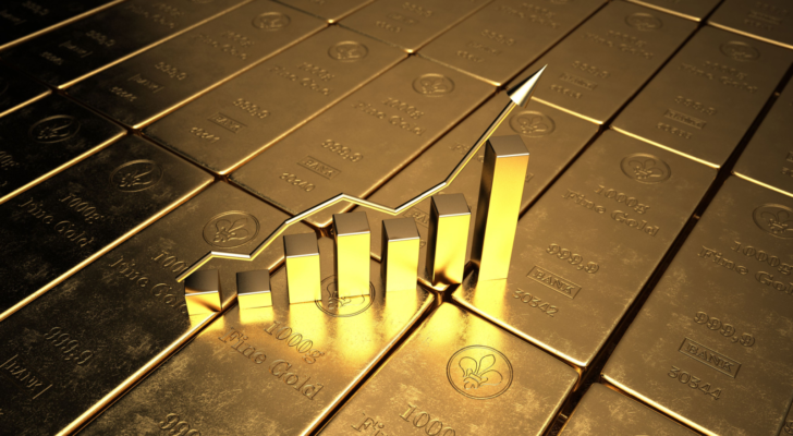 An image of a rising bar graph on top of gold bars, representing gold stocks