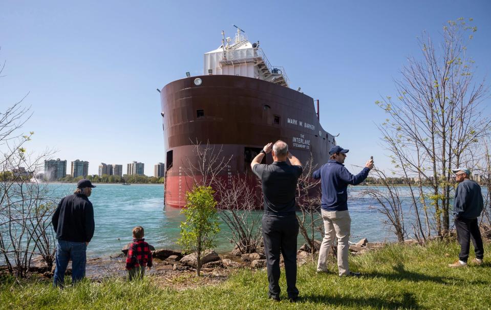 People gather near the Belle Isle shore to take photos of the Mark W. Barker, a large freighter that ran aground on the Canadian side of Belle Isle in Detroit on Wednesday, May 17, 2023.