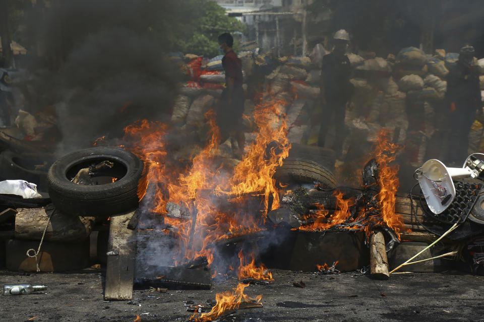 Anti-coup protesters are seen behind their makeshift barricade that protesters burn to make defense line during a demonstration in Yangon, Myanmar, Sunday, March 28, 2021. Protesters in Myanmar returned to the streets Sunday to press their demands for a return to democracy, just a day after security forces killed more than 100 people in the bloodiest day since last month's military coup. (AP Photo)