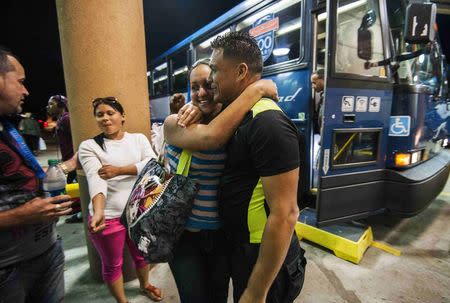 Cuban migrant Mailin Perez (3rd L) is greeted by her husband Jose Caballero after arriving via Mexico at a bus station in Austin, Texas September 25, 2014. REUTERS/Ashley Landis