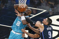 Charlotte Hornets center Bismack Biyombo (8) is fouled by Orlando Magic center Nikola Vucevic (9) as he goes up for a shot during the second half of an NBA basketball game, Monday, Jan. 25, 2021, in Orlando, Fla. (AP Photo/John Raoux)