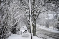 A worker shovels snow off a sidewalk Tuesday, Feb. 13, 2024, in Providence, R.I. Parts of the Northeast were hit Tuesday by a snowstorm that canceled flights and schools and prompted warnings for people to stay off the roads, while some areas that anticipated heavy snow were getting less than that as the weather pattern changed. (AP Photo/David Goldman)