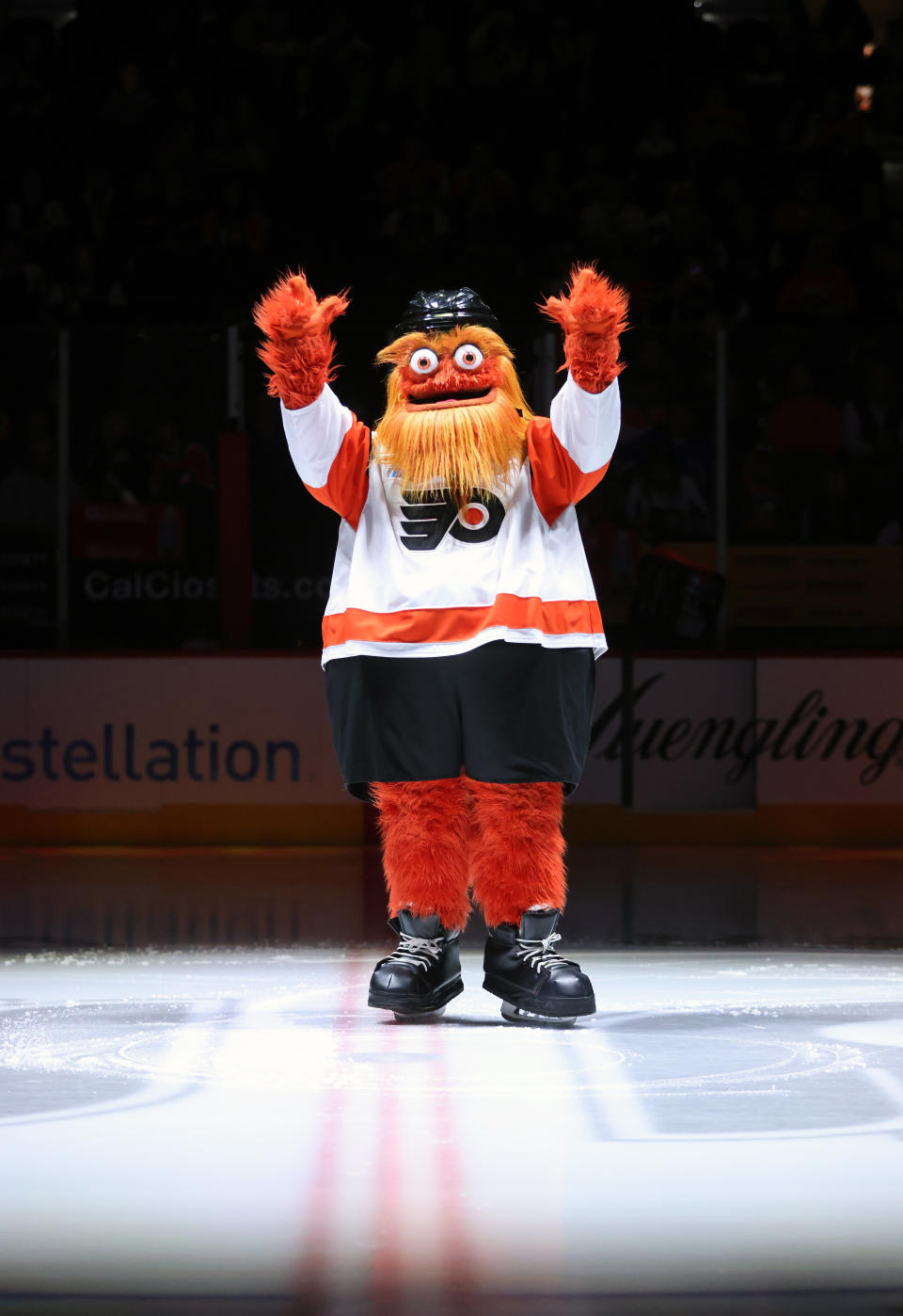 Gritty, the Philadelphia Flyers mascot, stands on the ice with arms raised during an event