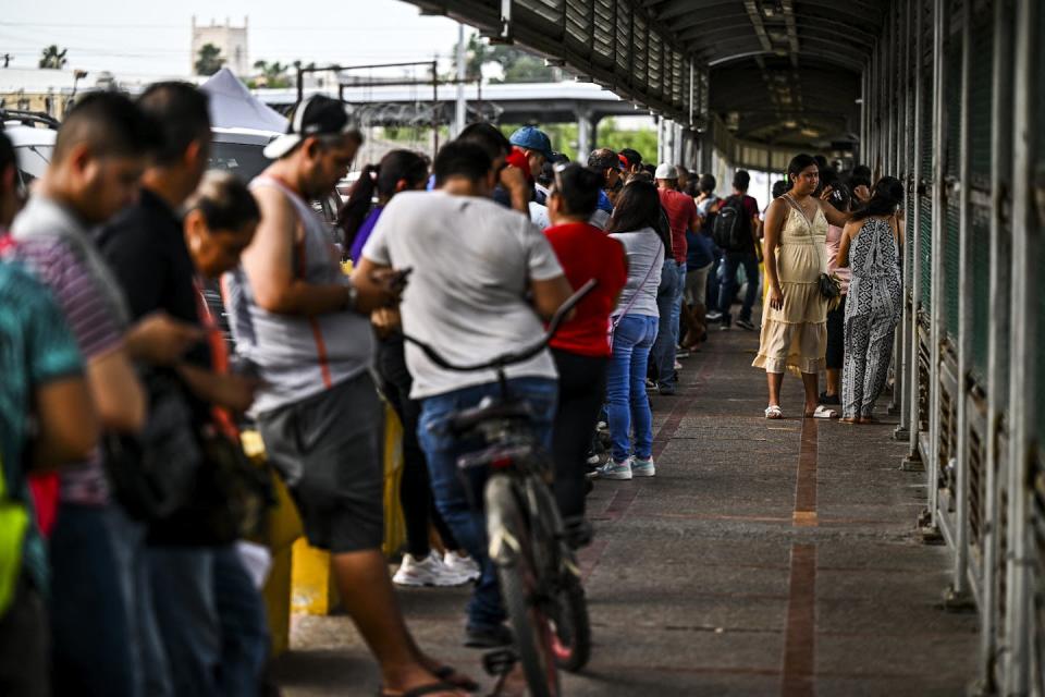 Migrants, mostly from Central America, wait in line to cross the border from Matamoros, Mexico, to Brownsville, Texas, on June 4, 2024. <a href="https://www.gettyimages.com/detail/news-photo/migrants-mostly-form-central-america-wait-in-line-to-cross-news-photo/2155466582?adppopup=true" rel="nofollow noopener" target="_blank" data-ylk="slk:Chandan Khanna/AFP via Getty Images;elm:context_link;itc:0;sec:content-canvas" class="link ">Chandan Khanna/AFP via Getty Images</a>