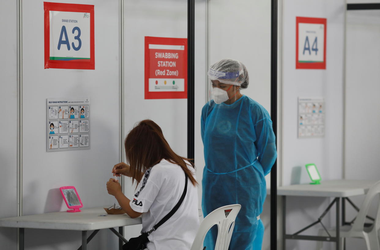 A woman takes her antigen rapid test under supervision at a Quick Test Centre during the coronavirus disease (COVID-19) outbreak, in Singapore September 28, 2021. REUTERS/Edgar Su