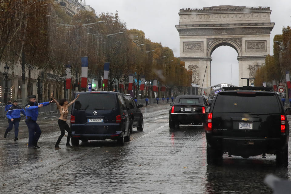 EDS NOTE NUDITY - French police officers run after a topless protestor who ran toward the motorcade of President Donald Trump who was headed on the Champs Elysees to an Armistice Day Centennial Commemoration at the Arc de Triomphe, Sunday Nov. 11, 2018, in Paris. Trump is joining other world leaders at centennial commemorations in Paris this weekend to mark the end of World War I. (AP Photo/Jacquelyn Martin)