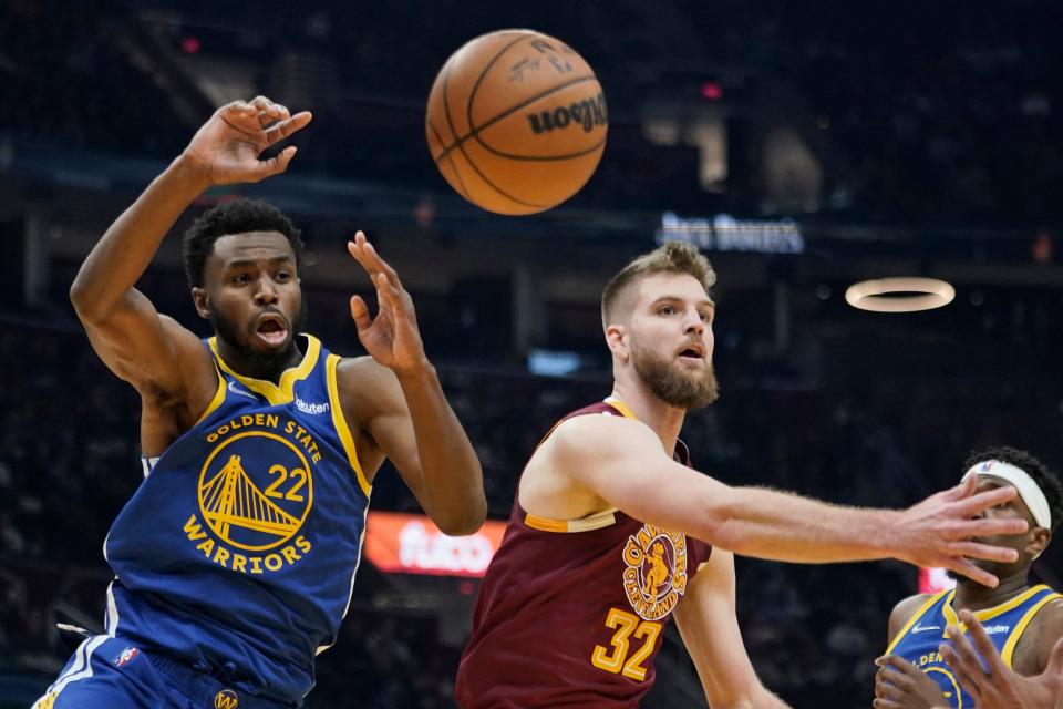 Cleveland Cavaliers' Dean Wade (32) and Golden State Warriors' Andrew Wiggins (22) battle for a rebound in the first half of an NBA basketball game, Thursday, Nov. 18, 2021, in Cleveland. (AP Photo/Tony Dejak)