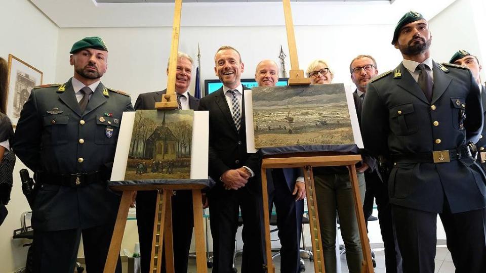 Axel Ruger (C), director del museo Van Gogh, posa junto a dos pinturas recuperadas. Nápoles el 30 de septiembre de 2016.