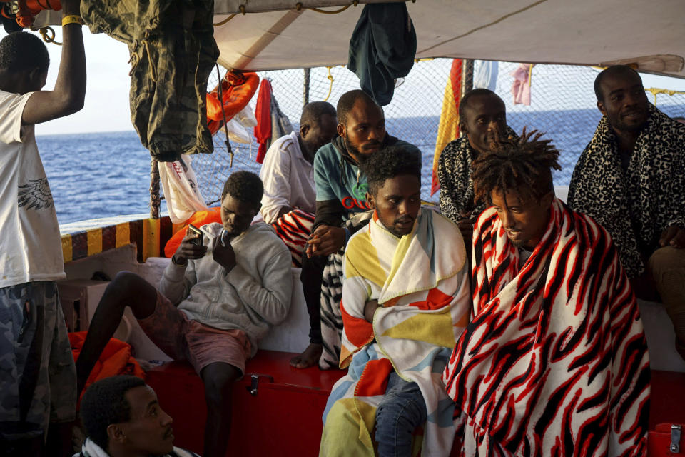Migrants sit aboard the Open Arms Spanish humanitarian boat as it arrives near Lampedusa coast in the Mediterranean Sea, Thursday, Aug.15, 2019. A Spanish aid boat with 147 rescued migrants aboard is anchored off a southern Italian island as Italy's ministers spar over their fate. (AP Photo/Francisco Gentico)