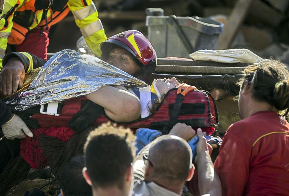 <p>An injured woman is carried by rescuers in Amatrice, central Italy, where a 6.1 earthquake struck just after 3:30 a.m., Italy, 24 August 2016. (Massimo Percossi/ANSA via AP) </p>