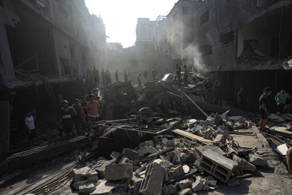 Palestinians search for bodies and survivors in the rubble of a residential building leveled in an Israeli airstrike, Al Shati Refugee Camp Thursday, Oct. 12, 2023. Israel's retaliation has escalated after Gaza's militant Hamas rulers launched an unprecedented attack on Israel Saturday, killing over 1,200 Israelis and taking captive dozens. Heavy Israeli airstrikes on the enclave has killed over 1,200 Palestinians. (AP Photo/Fatima Shbair)