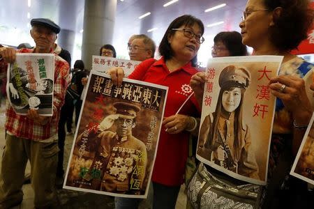 Protesters hold printouts depicting legislator-elect Yau Wai-ching (R) and Baggio Leung (C) as traitors during a demonstration outside the Legislative Council in Hong Kong, China October 19, 2016. REUTERS/Bobby Yip