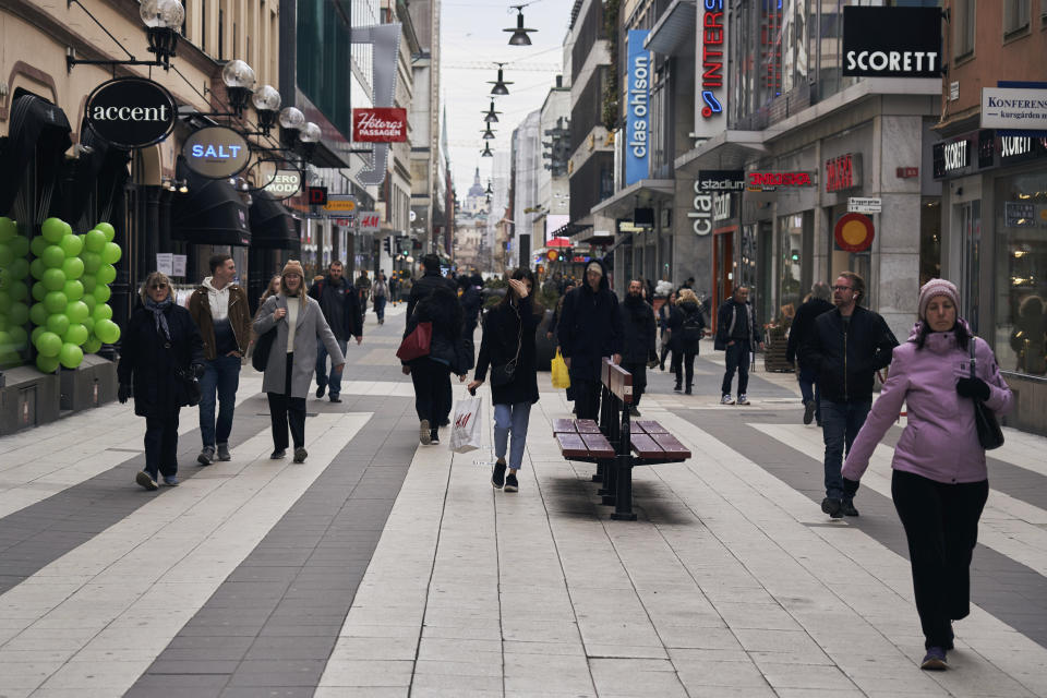 People walk along the main pedestrian shopping street in Stockholm, Wednesday, March 25, 2020. The streets of Sweden's capital are quiet but not deserted. Sweden has some of the most relaxed measures in Europe in the fight against the coronavirus outbreak. So far, only gatherings of over 500 people are banned and elementary and middle schools remain open. The new coronavirus causes mild or moderate symptoms for most people, but for some, especially older adults and people with existing health problems, it can cause more severe illness or death. (AP Photo/David Keyton)