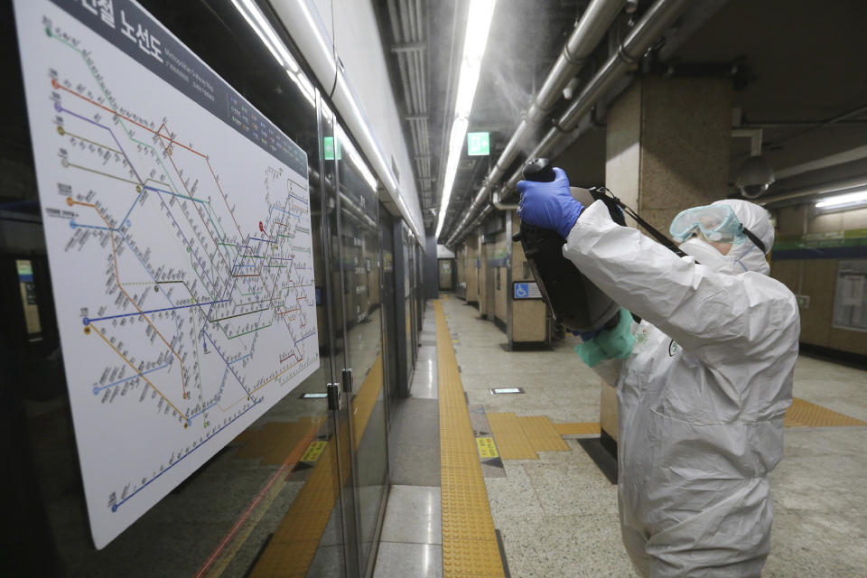 A worker wearing protective gears sprays disinfectant as a precaution against the coronavirus at a subway station in Seoul, South Korea, Friday, Feb. 21, 2020. South Korea on Friday declared a "special management zone" around a southeastern city where a surging viral outbreak, largely linked to a church in Daegu, threatens to overwhelm the region's health system. (AP Photo/Ahn Young-joon)