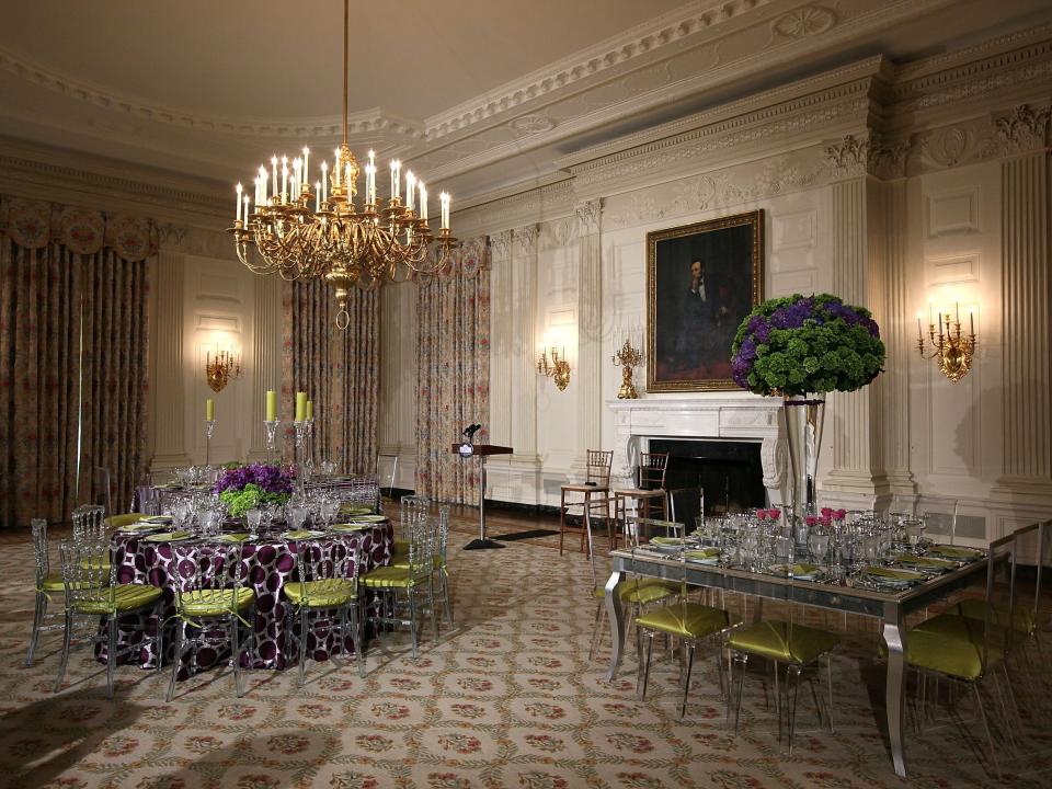 The State Dining Room set for a state dinner with purple and green colors in 2012.