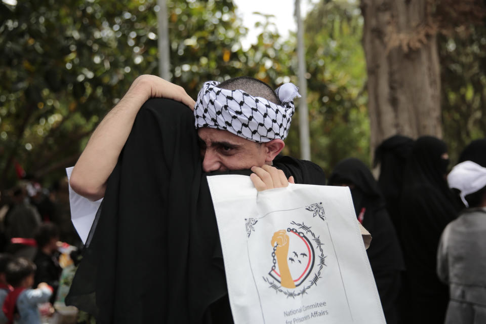 A Houthi prisoner hugs his mother as he arrives to Sanaa airport, Saturday, April 15, 2023. An exchange of more than 800 prisoners linked to Yemen's long-running war them began Friday, the International Committee for the Red Cross said. The three-day operations will see flights transport prisoners between Saudi Arabia and Yemen's capital, Sanaa, long held by the Iranian-backed Houthi rebels. (AP Photo/Hani Mohammed)