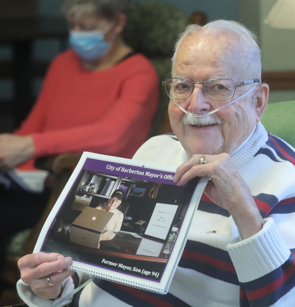 Former Barberton Mayor and Pleasant Point Assisted Living resident Kenneth Cox poses with a copy of the Senior Calendar where he appears at the Barberton Mayor's Office.