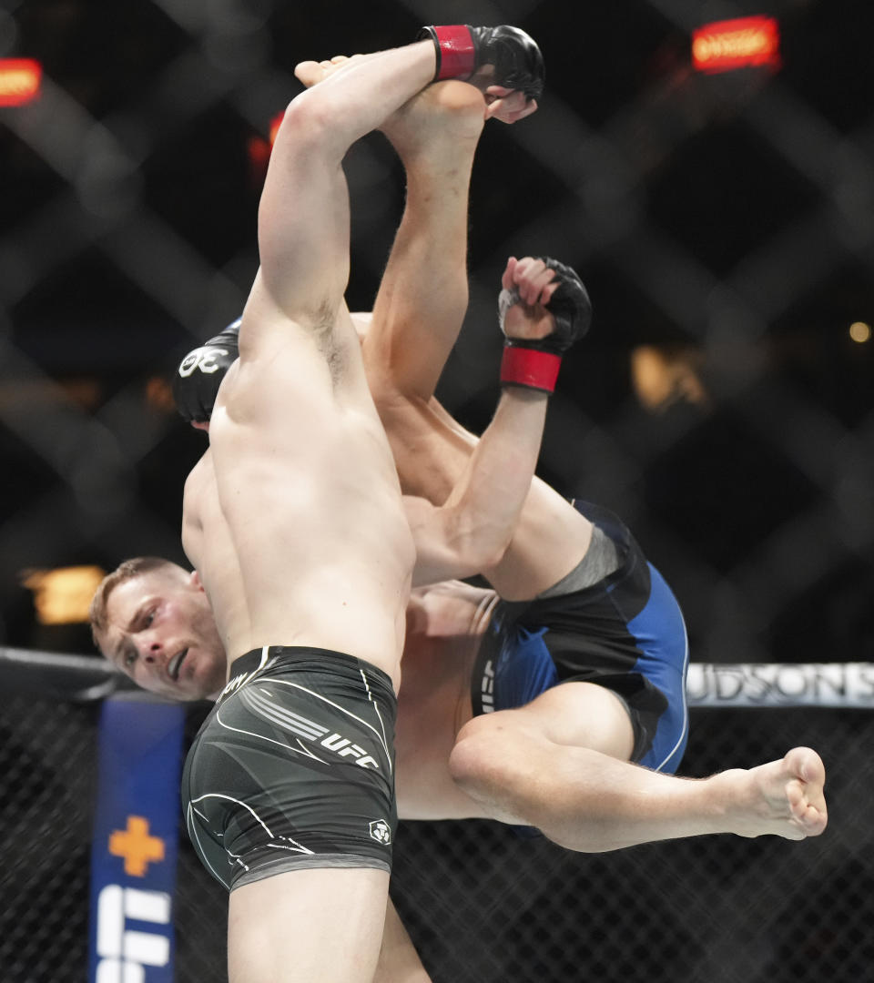 Mike Malott, front, picks up Adam Fugitt during a welterweight bout at UFC 289 in Vancouver, British Columbia on Saturday, June 10, 2023. (Darryl Dyck/The Canadian Press via AP)