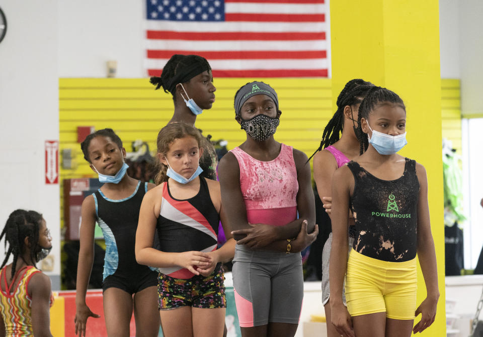 Girls wait in line to practice gymnastics, Thursday, July 22, 2021, at Power Moves Gymnastics and Fitness in Cedarhurst, N.Y. The face of gymnastics in the United States is changing. There are more athletes of color starting — and sticking — in a sport long dominated by white athletes at the highest levels. (AP Photo/Mark Lennihan)