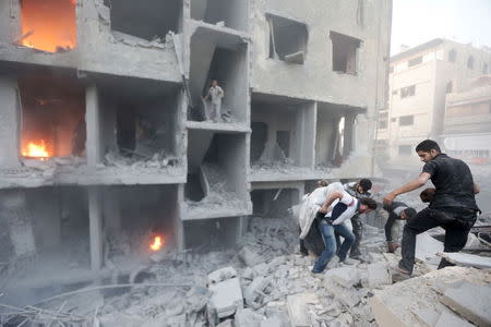 Men search for survivors at a site hit by what activists said was heavy shelling by forces loyal to Syria's President Bashar al-Assad in the Douma neighborhood of Damascus June 16, 2015. REUTERS/Bassam Khabieh