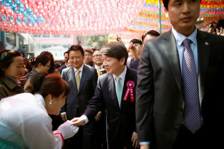 Ahn Cheol-soo, presidential candidate of the People's Party, shakes hands with his supporters after attending a ceremony celebrating the birthday of Buddha at Jogye temple in Seoul, South Korea, May 3, 2017. REUTERS/Kim Hong-Ji