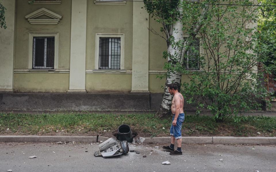 A civilian inspects a projectile that struck a street during Russian attacks in Bakhmut, Ukraine - Diego Herrera Carcedo/Anadolu Agency