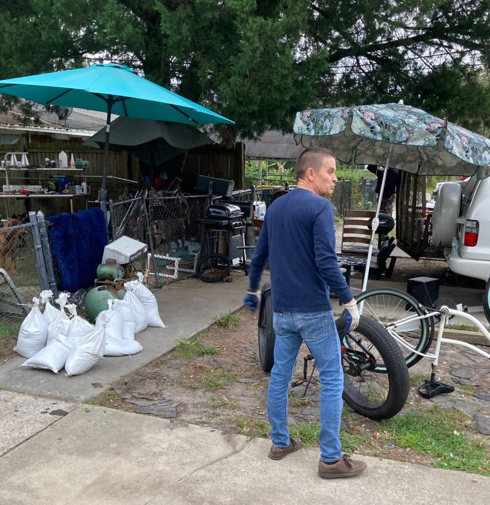 Barry Wilson leaves sandbags stacked outside the fence of a home on Jacksonville's Ken Knight Drive North as volunteers and residents on Wednesday helped the area prepare for Hurricane Ian's impacts.