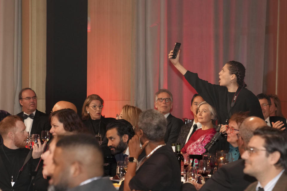 A protester films herself as she interrupts the Scotiabank Giller Prize in Toronto, on Monday, Nov. 13, 2023. The ceremony was twice interrupted by anti-Israel protests. (Chris Young/The Canadian Press via AP)