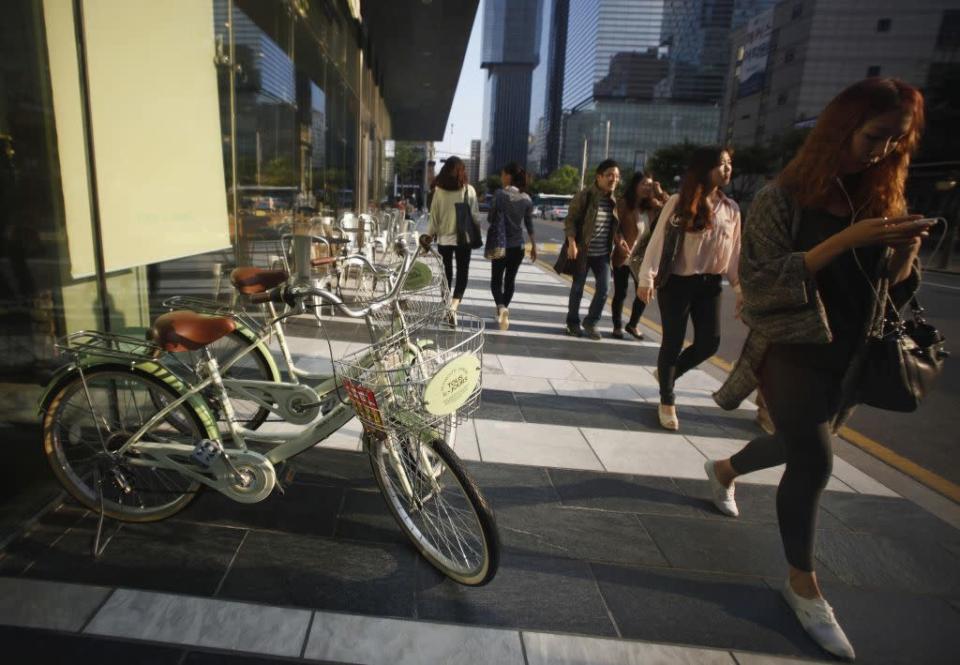 People walk on the street in the Gangnam area of Seoul.